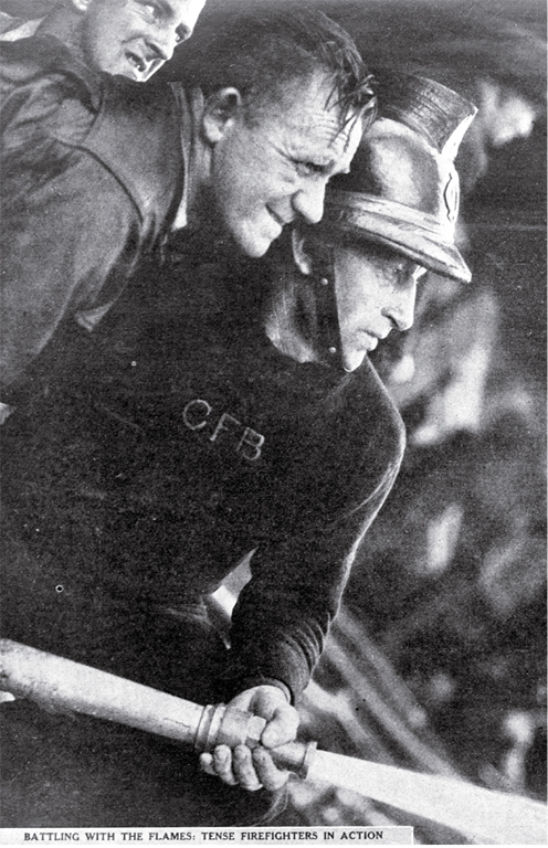 Battling the flames : tense firemen in action. Battling the flames : tense firemen in action.
