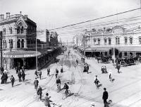 Looking down High Street while cyclists cross the intersection of Colombo and Hereford Streets