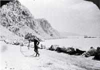 Cyclist beside a penny-farthing bicycle near Shag Rock on the Sumner road, Christchurch