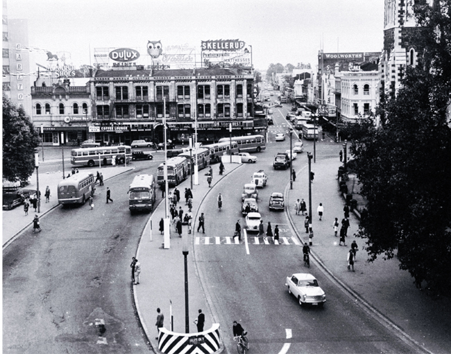 Cars and buses in Cathedral Square : view looking up Colombo Street, with the Colonial Mutual Life building behind the Cathedral Cars and buses in Cathedral Square : view looking up Colombo Street, with the Colonial Mutual Life building behind the Cathedral