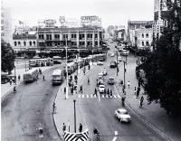 Cars and buses in Cathedral Square : view looking up Colombo Street, with the Colonial Mutual Life building behind the Cathedral