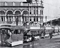 The 10 o'clock tram drawn by a Kitson steam locomotive leaving for Sumner outside the Royal Exchange Building