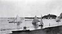 Yachts of the Christchurch Sailing Club fleet under sail near the pier at Cave Rock, Sumner