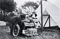 A camping holiday ideal for health and pleasure : touring by motorcycle, unpacking side-car in front of the tent.
