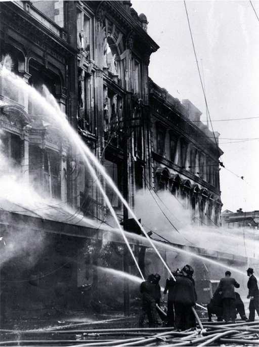 Firemen dampening down the main entrance of Ballantyne's, Colombo Street, Christchurch Firemen dampening down the main entrance of Ballantyne's, Colombo Street, Christchurch