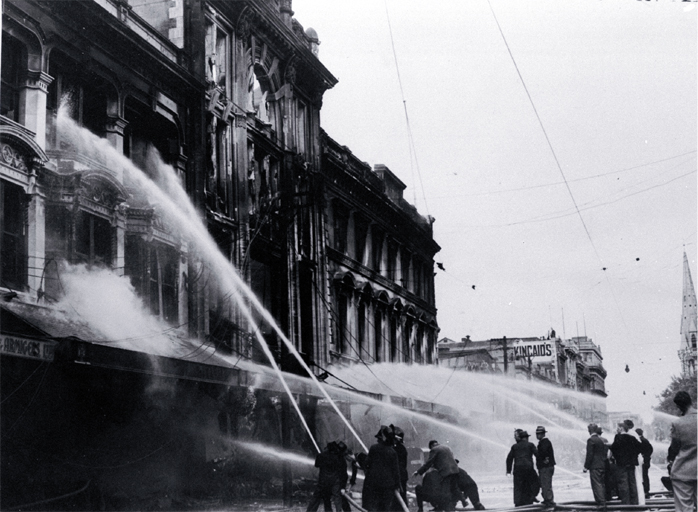 Firemen dampening down the main entrance of Ballantyne's building, Christchurch Firemen dampening down the main entrance of Ballantyne's building, Christchurch