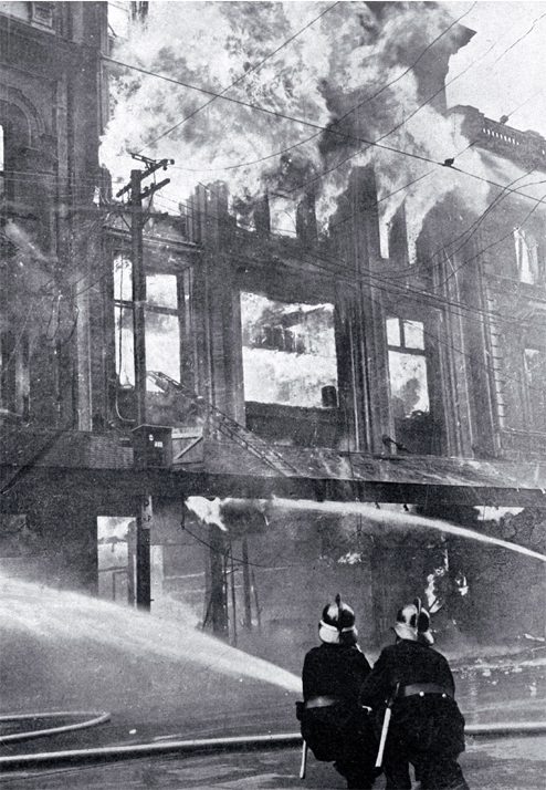 Firemen battling the blaze : directing jets on the furniture department. Firemen battling the blaze : directing jets on the furniture department.