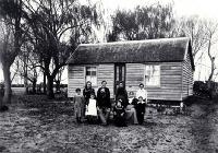The family of Arthur John Inwood (1850-1932) and his wife Angelina (1860?-1919) pictured outside their dwelling