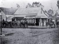 Meat hangs outside G. Bull's butchery in Cashel Street, Christchurch, with delivery carts waiting