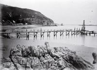 Construction of the Sumner Pier, Christchurch : looking from Cave Rock past the Sumner Hotel to Clifton Spur and Shag Rock.