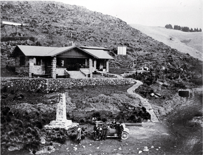 A car and excursionists in front of the Sign of the Kiwi, Dyers Pass, Summit Road, Christchurch A car and excursionists in front of the Sign of the Kiwi, Dyers Pass, Summit Road, Christchurch