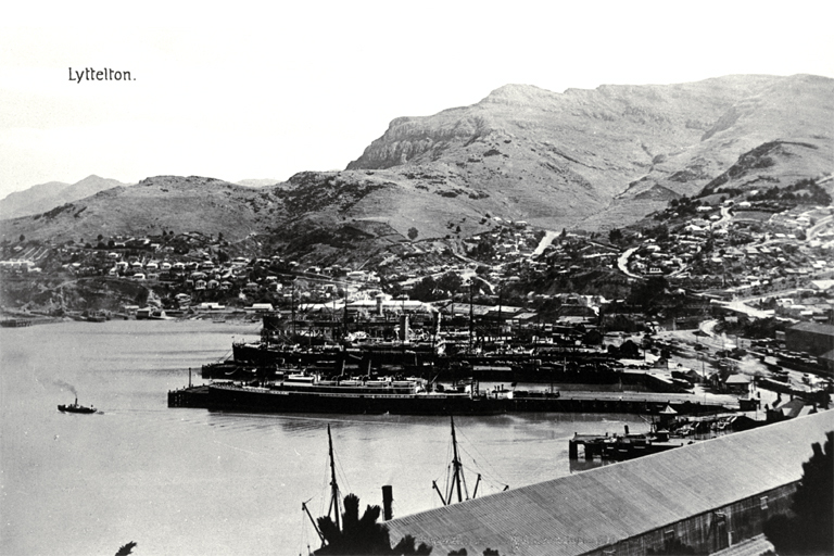 Lyttelton Harbour with ships at dock and tugboat on the water Lyttelton Harbour with ships at dock and tugboat on the water