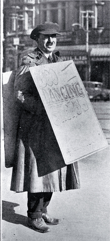 A sandwich-board man advertising dancing shoes in Cathedral Square, Christchurch A sandwich-board man advertising dancing shoes in Cathedral Square, Christchurch