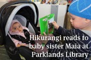 Hikurangi reads to his baby sister Maia at Parklands Library