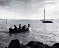 A motor boat approaches a moored yacht on the Estuary at Redcliffs 