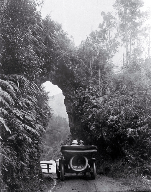 A Model T Ford (Tin Lizzie) travelling under a rock arch in the Buller Gorge, Westland A Model T Ford (Tin Lizzie) travelling under a rock arch in the Buller Gorge, Westland