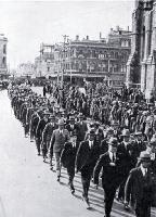 Returned soldiers in mufti and wearing medals marching past the Cathedral, Christchurch