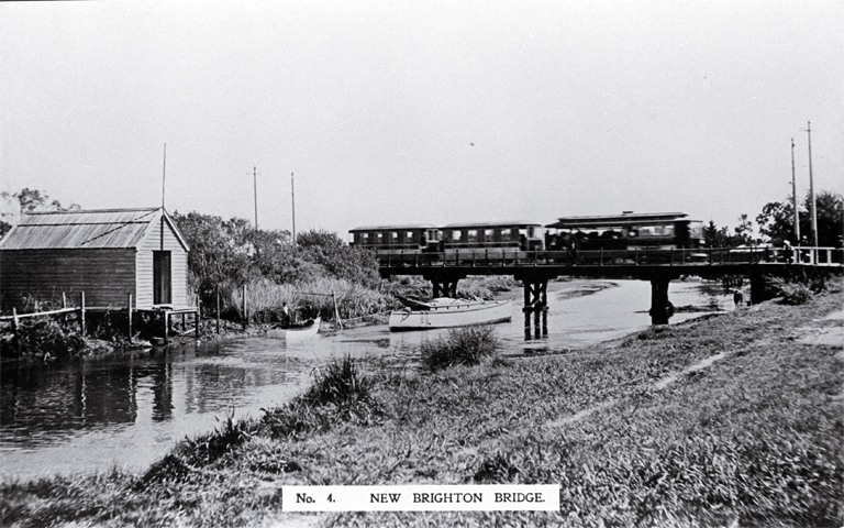 An electric tram crosses the New Brighton bridge with a barge moored underneath An electric tram crosses the New Brighton bridge with a barge moored underneath