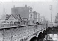 A boy leans on the Hereford Street bridge, Christchurch, looking to the east
