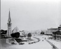 Horses & carts around the Godley statue in Cathedral Square : with a Kitson steam locomotive moving through the centre of the Square.