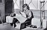 A shoe-shine man reads a newspaper while waiting in Cathedral Square for customers, Christchurch